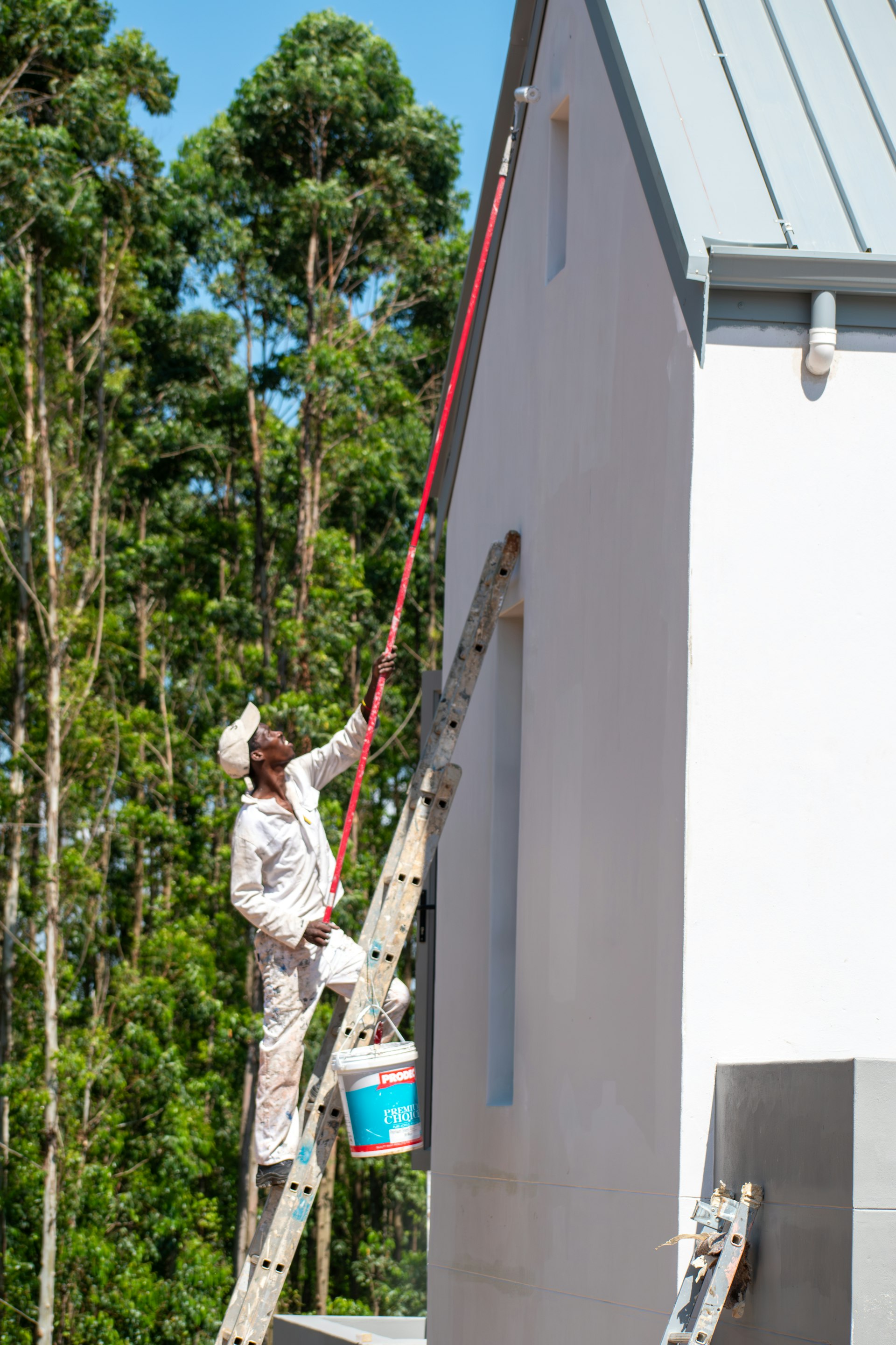Painter coating a building exterior